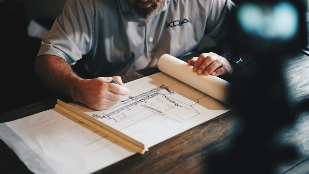 Architectural drawings, construction blueprints, and precision drafting tools on a project work table
